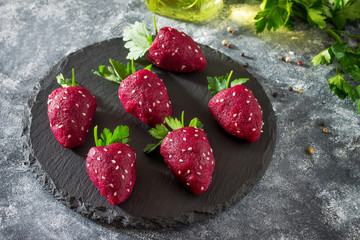 Vegan strawberry snack of boiled beets stuffed with herring on a slate board. healthy eating concept.