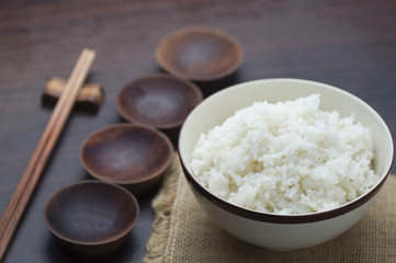 Thai rice with chopsticks on wood background