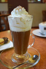 Viennese coffee with whipped cream on glass cup.