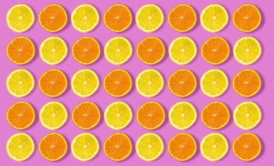 Colorful fruit pattern of fresh orange and lemon slices on pink background. From top view