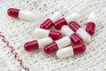 Some white and red pills wrapped in gauze