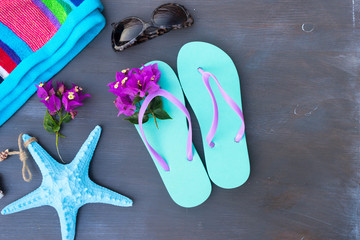 Summer beach fun - sandals with sunglasses, flowers and starfish