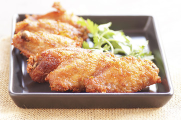Close up Spicy Deep Fried Breaded Chicken Wings with Ranch and coriander on black plate