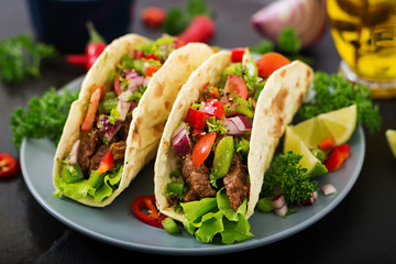 Mexican tacos with beef in tomato sauce and salsa