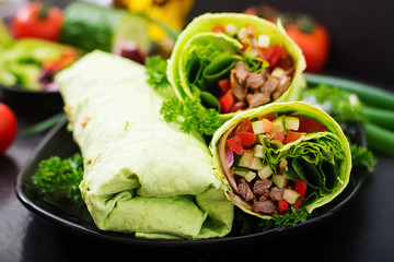 Shawarma from juicy beef, lettuce, tomatoes, cucumbers, paprika and onion in pita bread with spinach. Diet menu