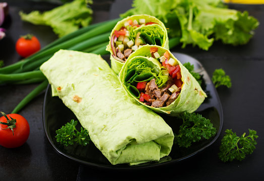 Shawarma from juicy beef, lettuce, tomatoes, cucumbers, paprika and onion in pita bread with spinach. Diet menu