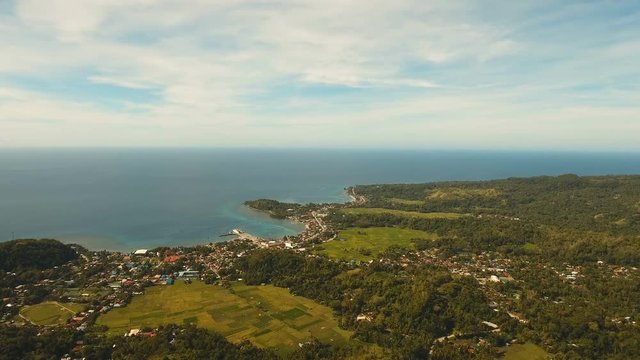 The town near the sea, houses, buildings, port. Aerial view coastal city nn the island of Bohol near the sea. Seascape with a town and the sea. 4K video. Travel concept. Aerial footage.