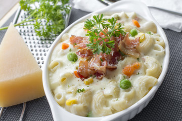 Homemade baked macaroni and cheese with grated parmesan cheese and bacon on top