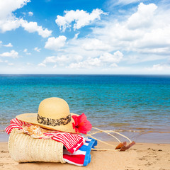 sunbathing accessories on beach in straw bag, summer relaxation and vacations concept