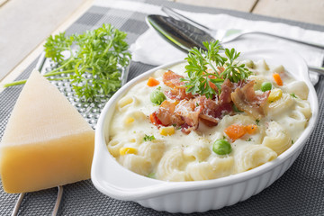 Homemade baked macaroni and cheese with grated parmesan cheese and bacon on top