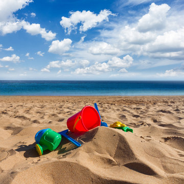 beach toys in sand on sea coast at sunny summer day