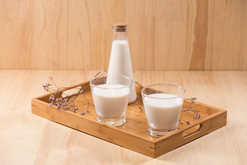 Dairy products. A bottle of milk and glass of milk on a wooden table.