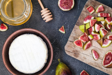 Ingredients layout for baking soft cheese brie with figs and honey. Snack concept. Top view on dark background