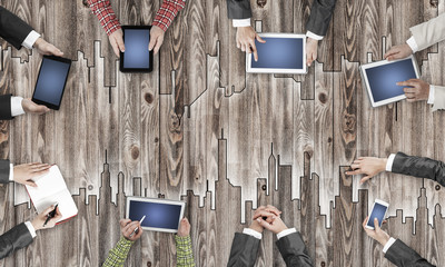 Top view of businesspeople sitting at table and using gadgets © adam121