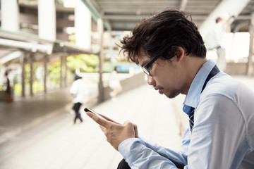 man worker is holding smartphone and using in feeling serious for something.