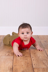 Naklejka premium Adorable baby boy laying on the floor