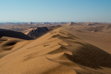 Summit of Big Daddy Dune Close up with Sand Blowing in the Wind and View onto Desert Landscape, Sossusvlei, Namibia