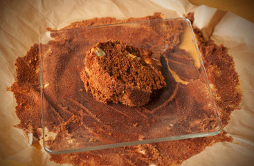 A slice of homemade cocoa cake with fruits on a glass plate