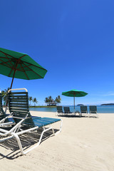 Tropical island vacation with deck chairs on white sand beach