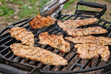 Grilling chicken fillets at a barbecue