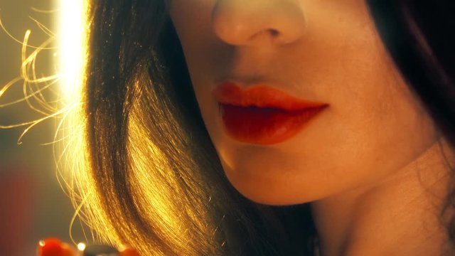 Young woman opens red lipstick. 4K shot