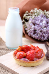 Tart with fresh strawberry on wooden background,