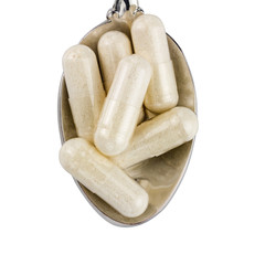 Capsules of glucosamine chondroitin, healthy supplement pills in the spoon isolated on white background, top view