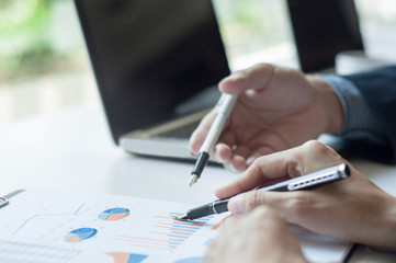 business executives discussing on data with laptop background