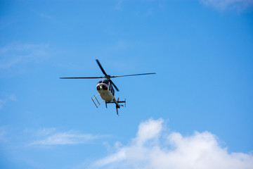 Fototapeta na wymiar Helicopter flying the blue sky