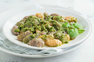 Gnocchi with carrots beets and spinach with pesto sauce on the plate.