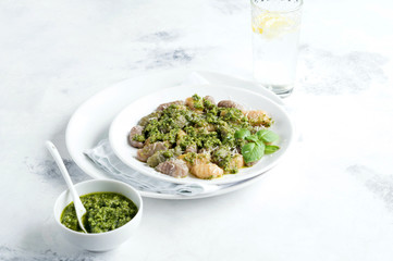 Gnocchi with carrots beets and spinach with pesto sauce on the plate.