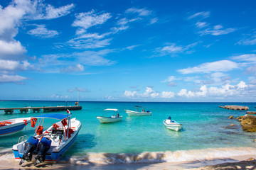 Boats with engine in the clear ocean on a background of palm trees and beautiful clouds.