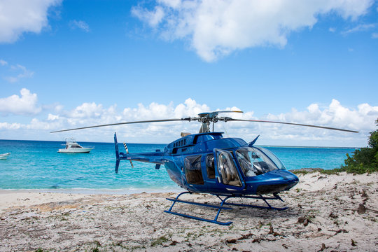 Blue helicopter on the beach on tree and beautiful ocean and clouds at backgorund