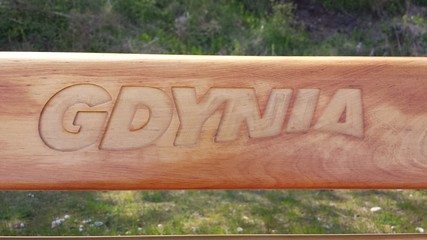 Inscription Gdynia engraved on a wooden bench