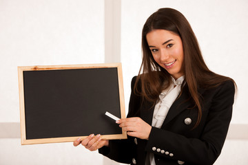 Beautiful young  business woman holding blank blackboard isolated over white background