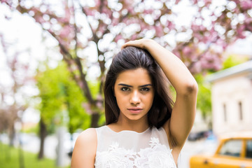 beautiful young woman in blooming sakura blossoms garden