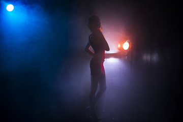 the girl's silhouette in fog against the background of light sources