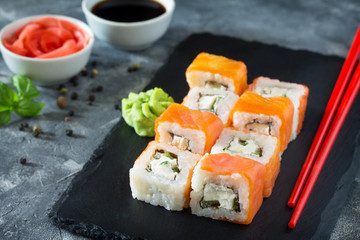 Roll Philadelphia classic on a black slate board - salmon, soft cheese, cucumber, nori, rice.
