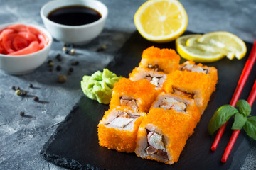 Roll Mr.Krabs on a black slate board - red tobiko caviar, mayonnaise, crab meat (imitation), tomato, nori, rice.