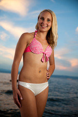 Young woman on the beach at sunset on a hot summer day