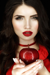 Beautiful woman portrait with nice make up, red lips and red apple in hands. Snow white.