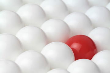 Difference concept, red ball in white balls. Conceptual image.