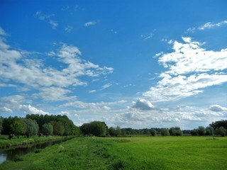 blauer Himmel und Wolken über typischer Niederrheinlandschaft