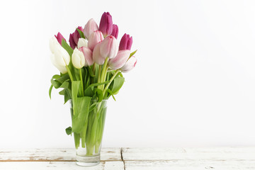 Bouquet of purple tulips on white wood
