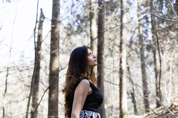 Portrait of beautiful woman in a forest, she is looking towards the sky