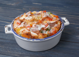 Freshly baked bread pudding in casserole dish on wooden table