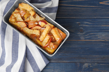 Freshly baked bread pudding in casserole dish on wooden table