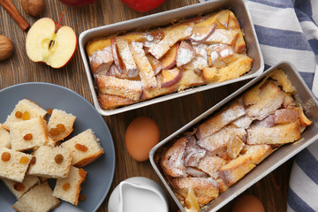 Freshly baked bread pudding in casserole dishes on wooden table