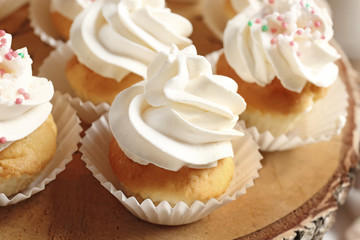 Wooden stand with tasty cupcakes, closeup