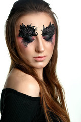 Girl close eyes with paper zigzag make-up and brown hair.Creative makeup.Red background